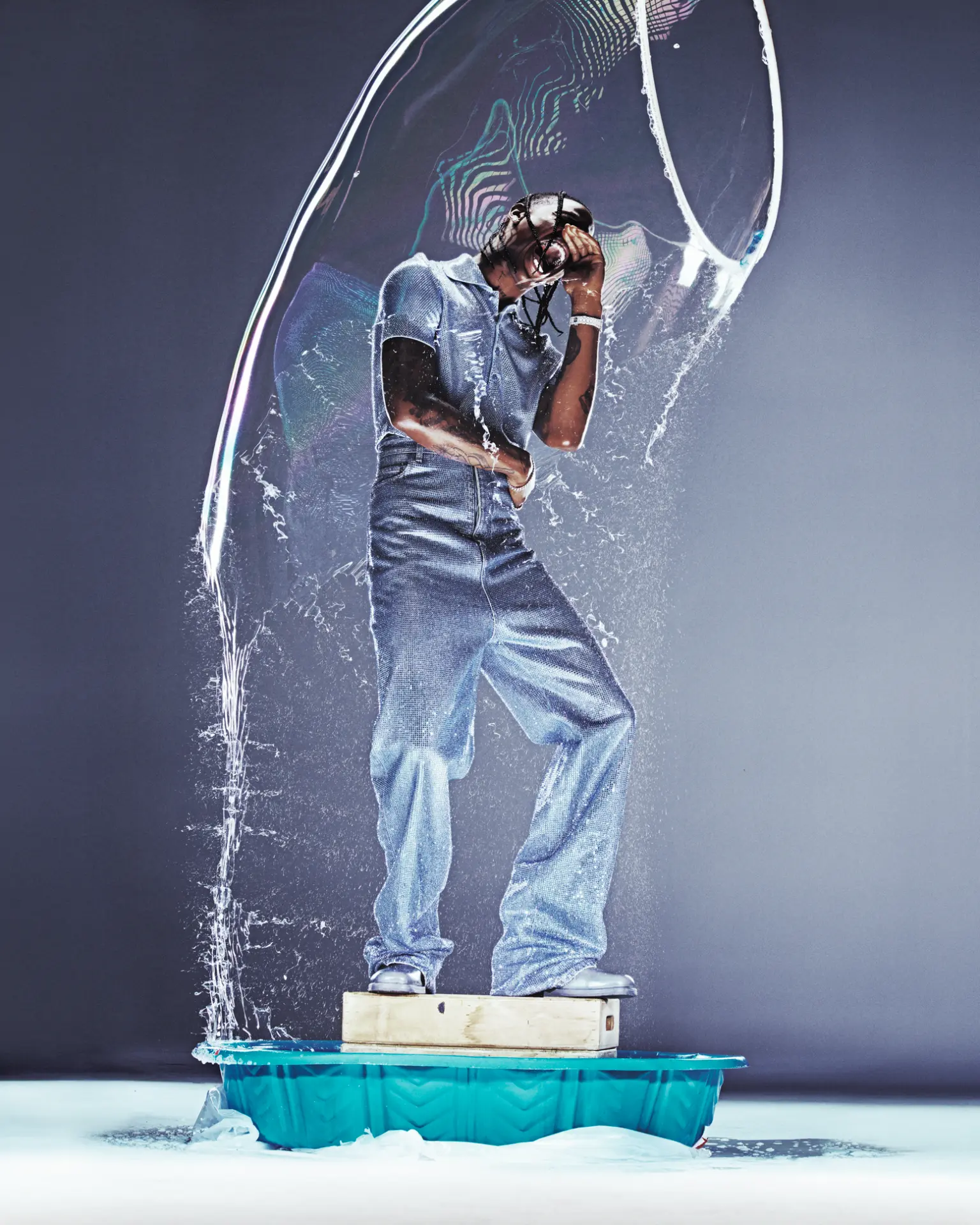 Travis Scott — denim figure inside a bursting water bubble
