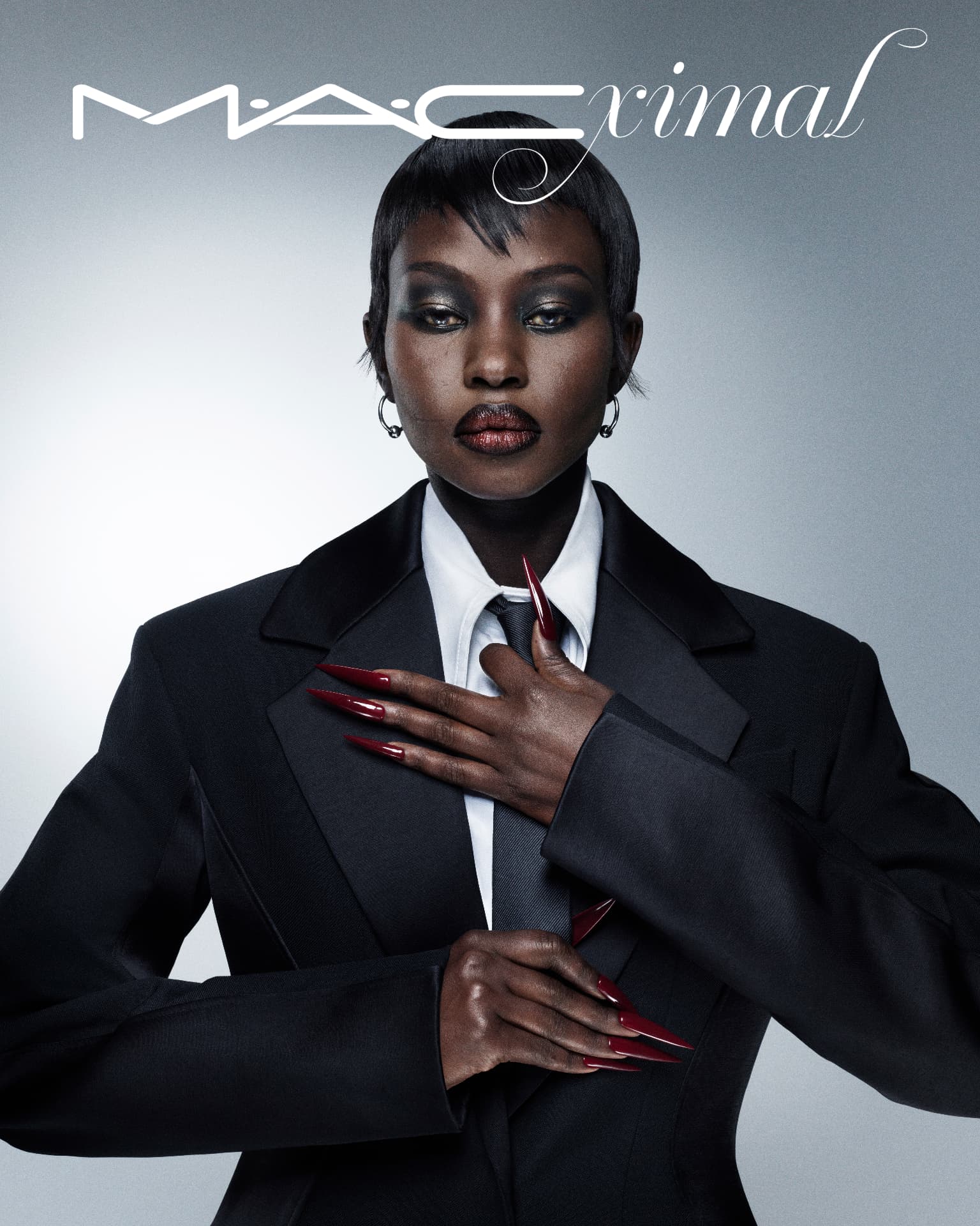 MACximal — model in black suit with red stiletto nails