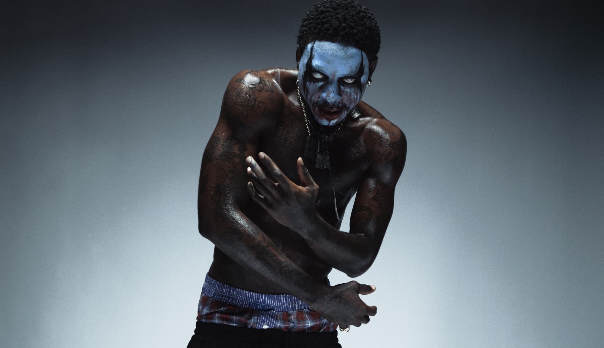 Slawn Halloween portrait with blue face paint and layered necklaces