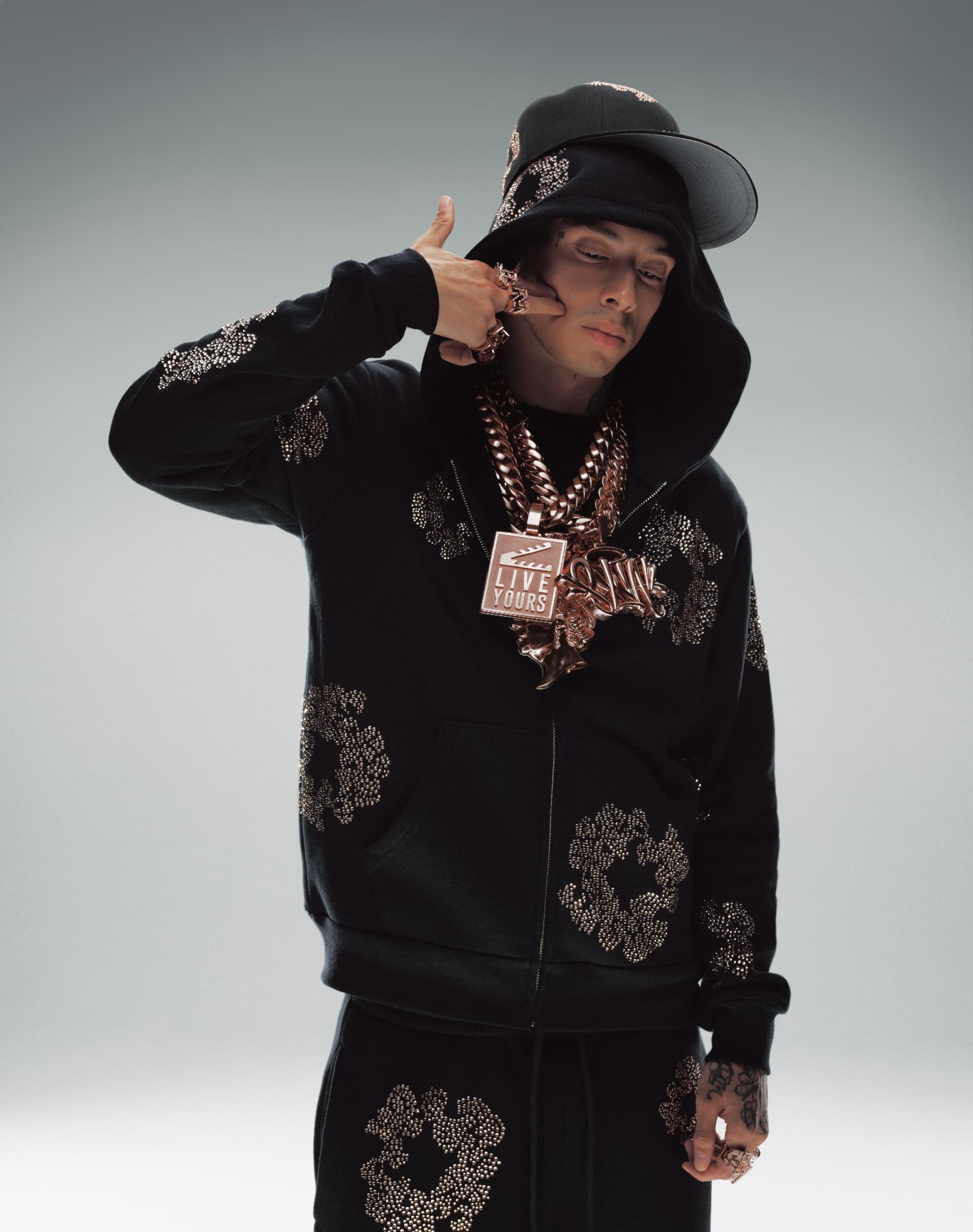 Central Cee — standing portrait in black studded tracksuit and bucket hat with rings