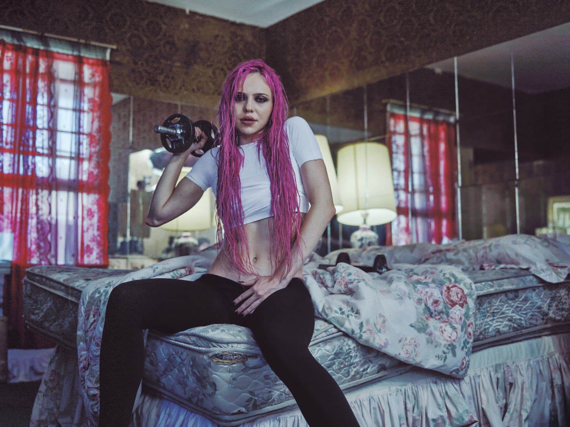 ADÉLA — V Magazine look with pink hair lifting a dumbbell on a motel bed