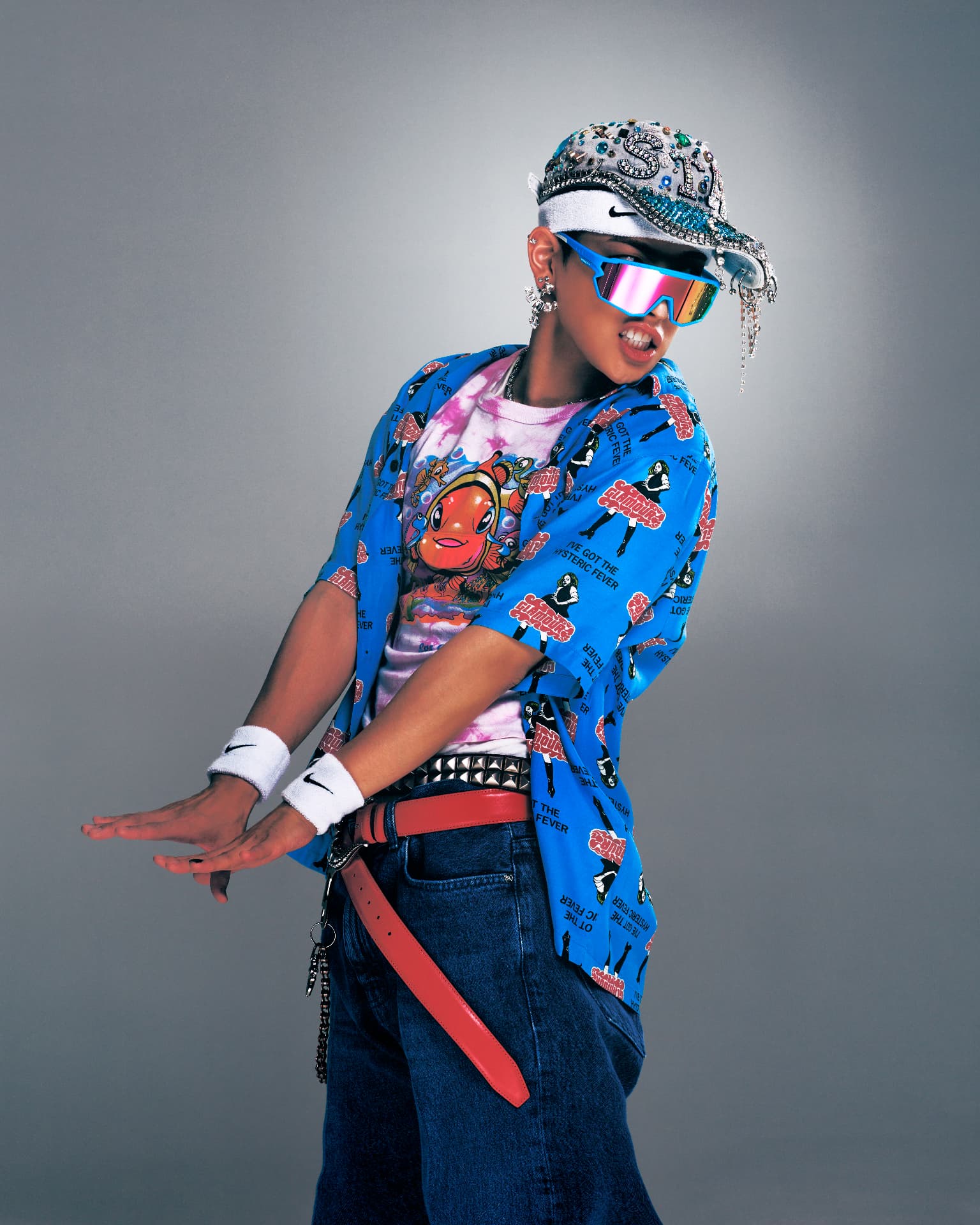 ATEEZ — figure in blue graphic top, studded belt and embellished cap