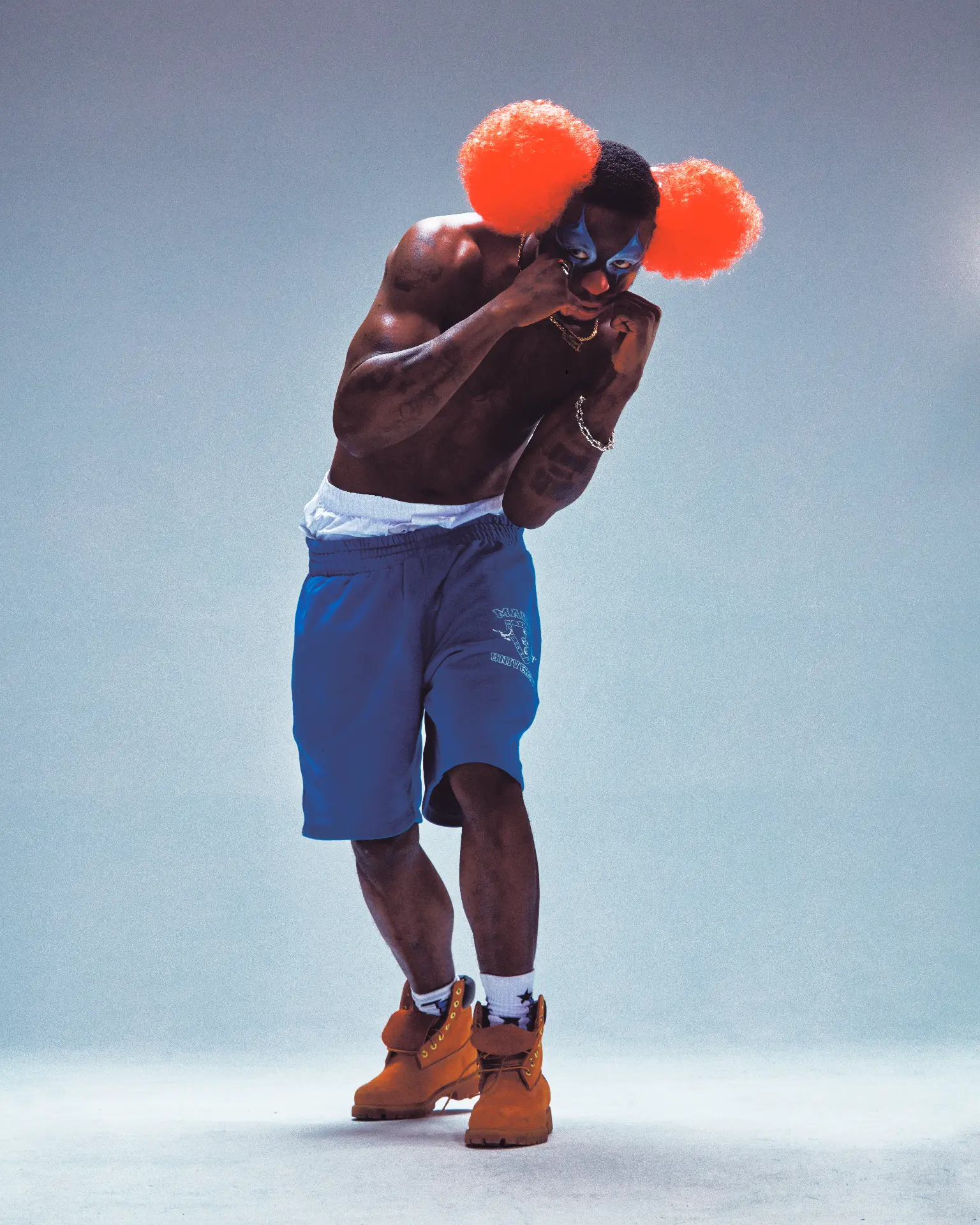 Slawn boxer with orange clown hair and blue face paint