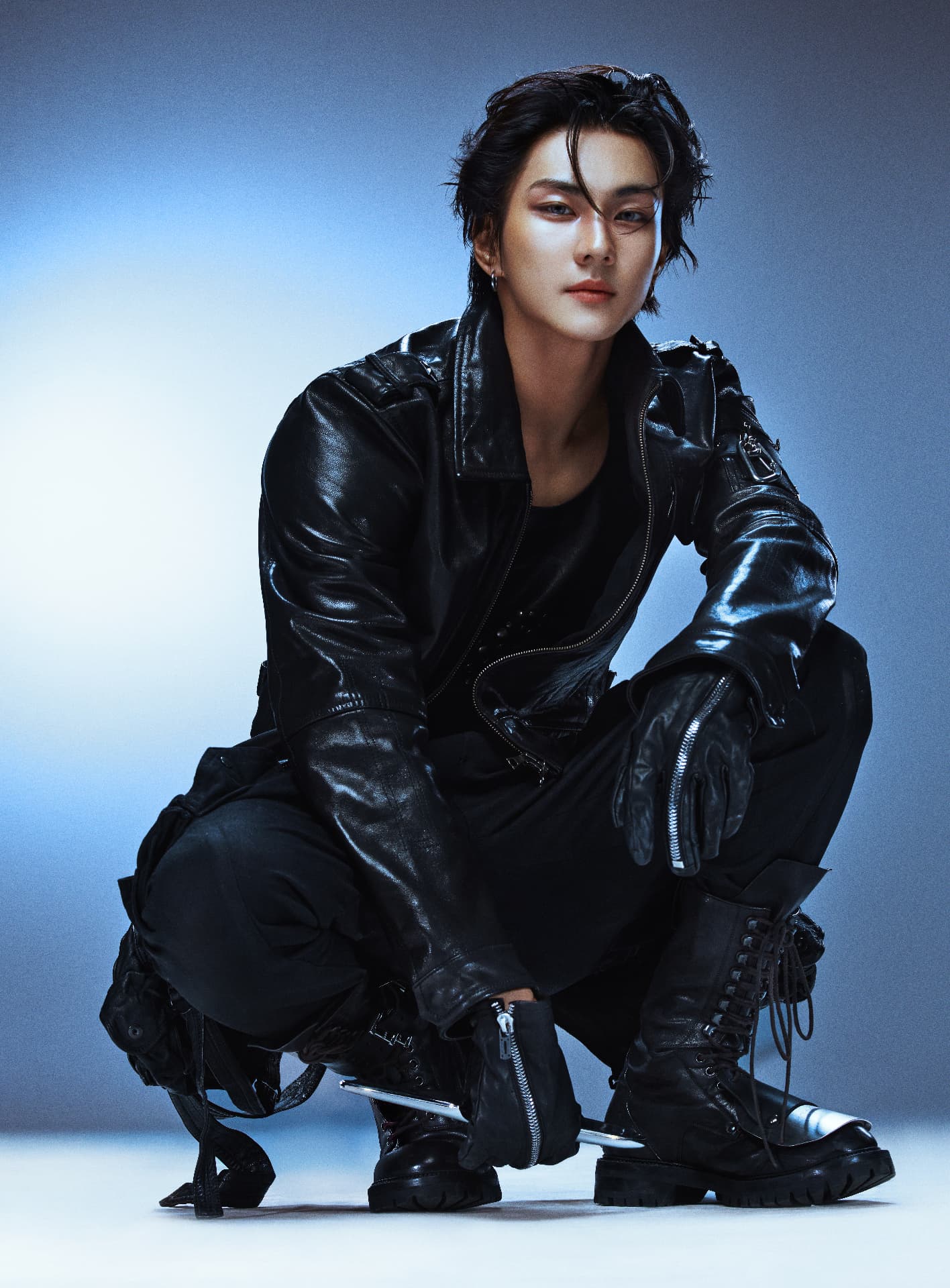 ENHYPEN — Jungwon crouched in black leather against blue light
