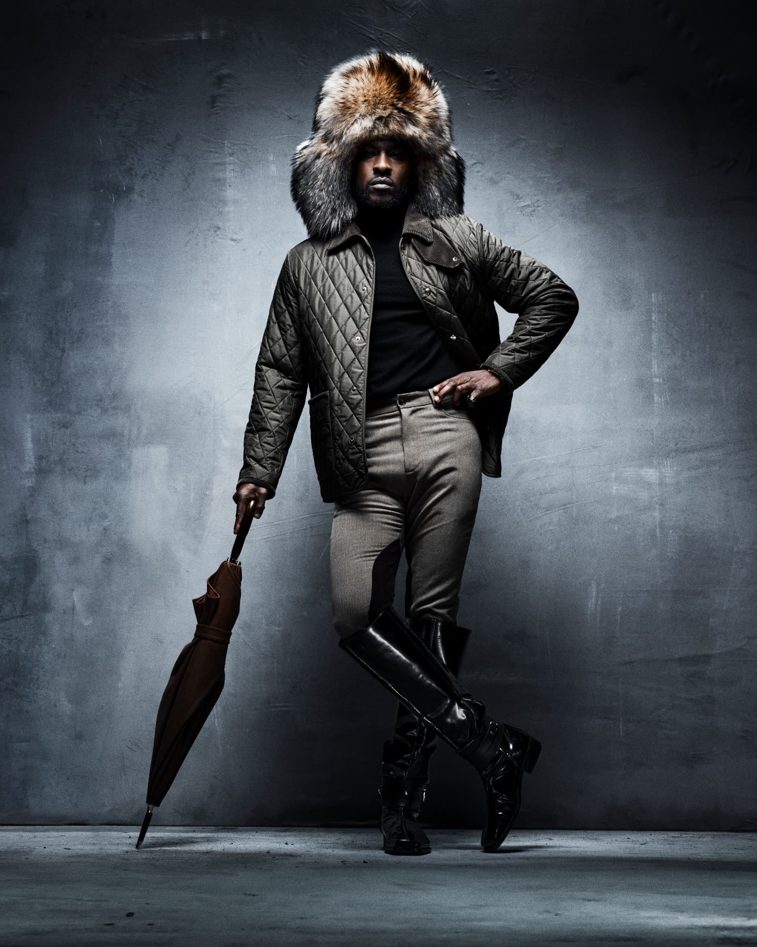 SKEPTA x GQ MOTY — standing portrait in fur-trimmed hood and umbrella