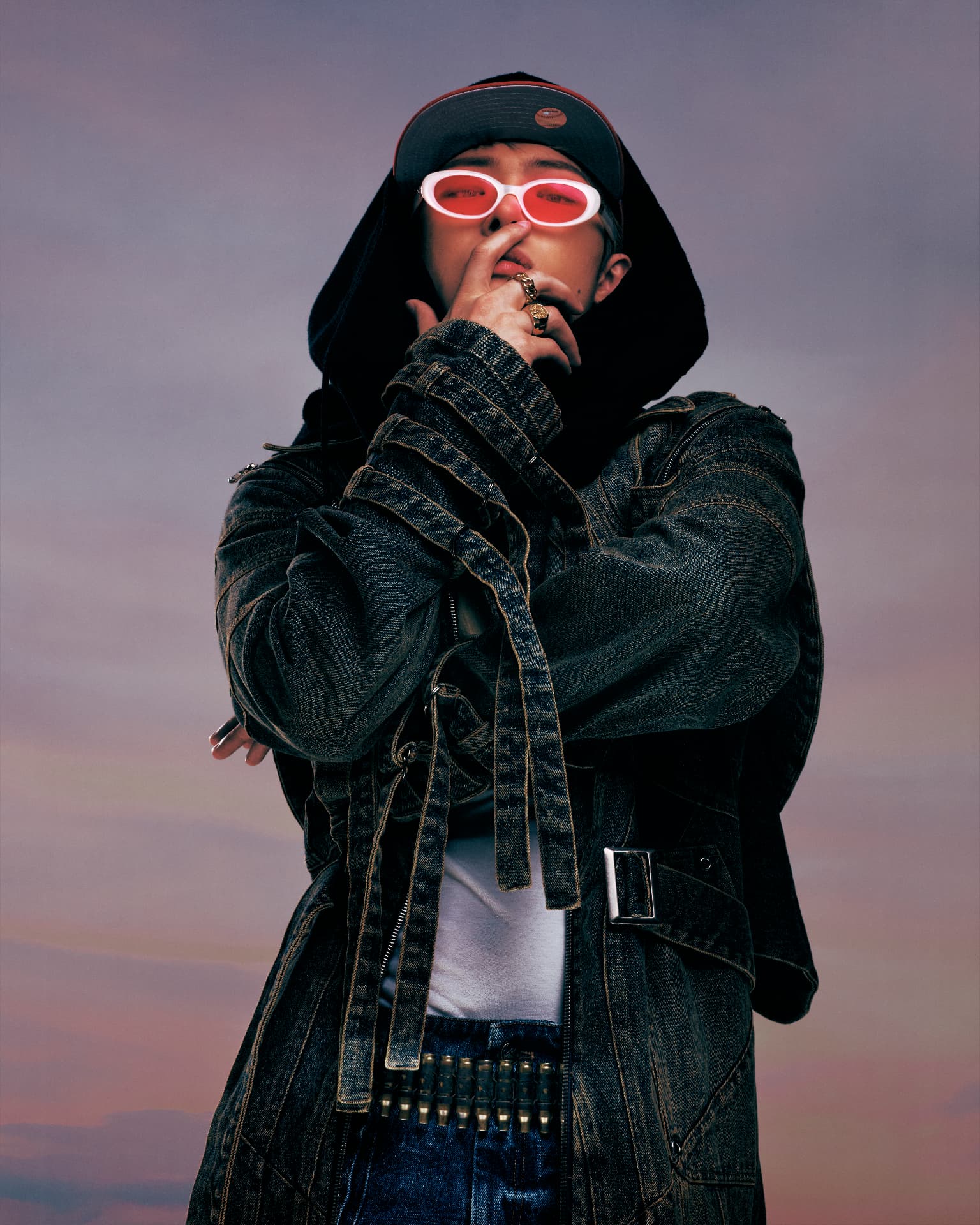 ATEEZ — figure in layered denim with hood and red-lensed glasses