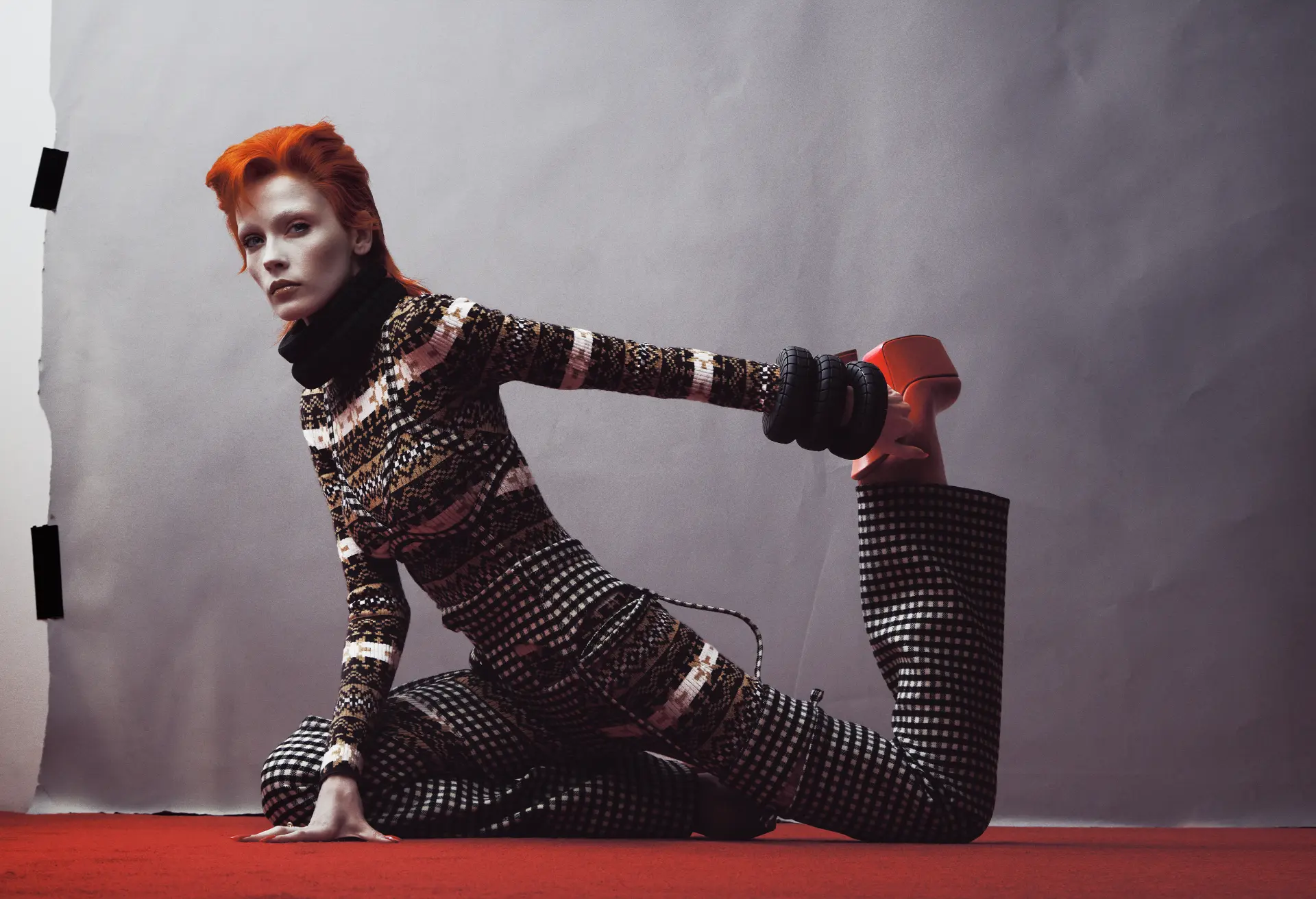 ZIGGY — patterned-knit figure stretching on red floor