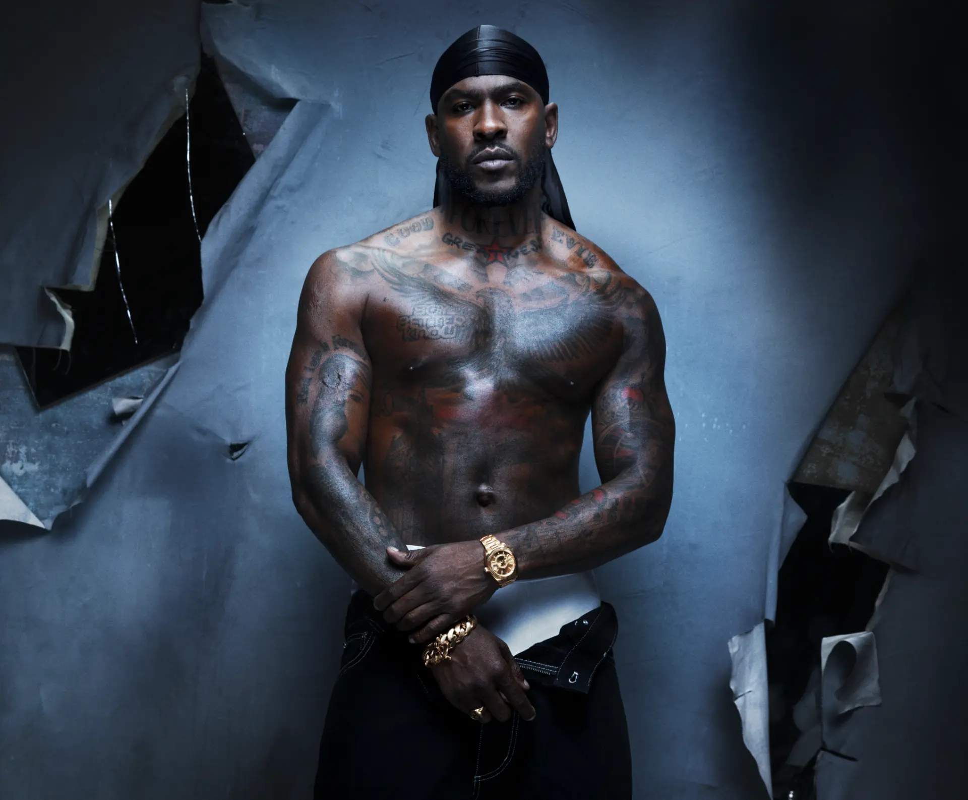 SKEPTA x GQ MOTY — shirtless portrait with gold watch against torn paper backdrop